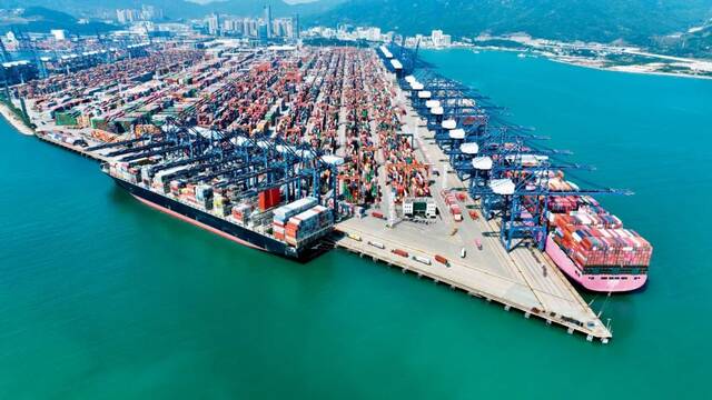2022年2月15日，大型集装箱船在广东深圳盐田港装卸货物。摄影/本刊记者陈文