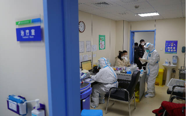 12月15日，在中国医科大学附属盛京医院南湖院区发热门诊，值班医生在为患者治疗。新华社图