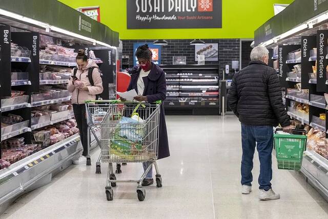 当地时间2022年10月20日，英国伦敦，购物者在超市购买产品。图/视觉中国
