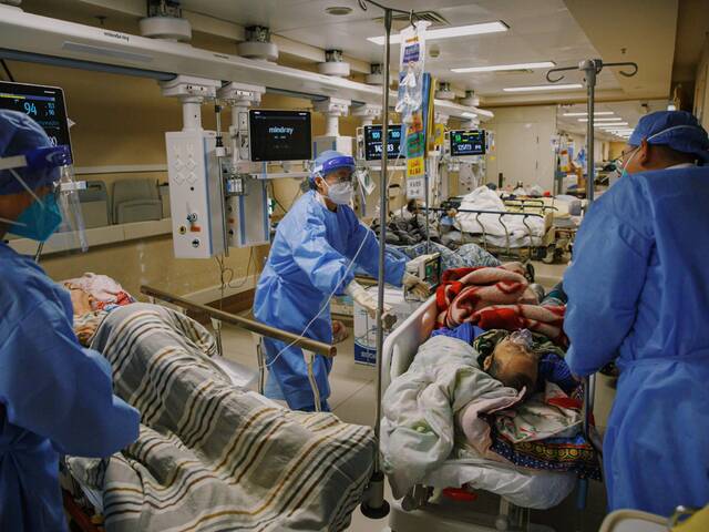 2022年12月27日晚，朝阳医院急诊科抢救室，医务人员腾挪床位接收新的病人。新京报记者郑新洽摄