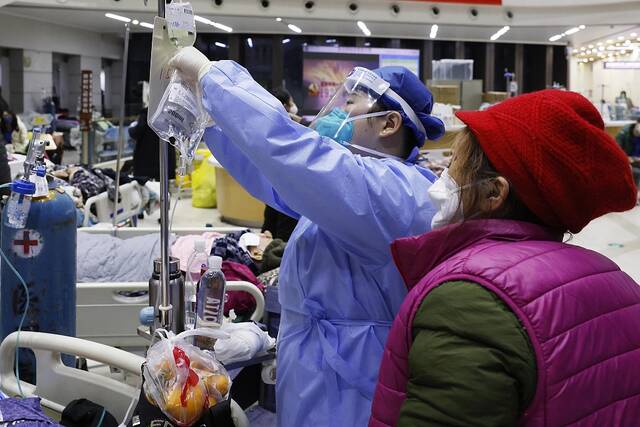 2022年12月31日晚，上海市第一人民医院虹口院区的医护人员为患者换药。中新社记者殷立勤图