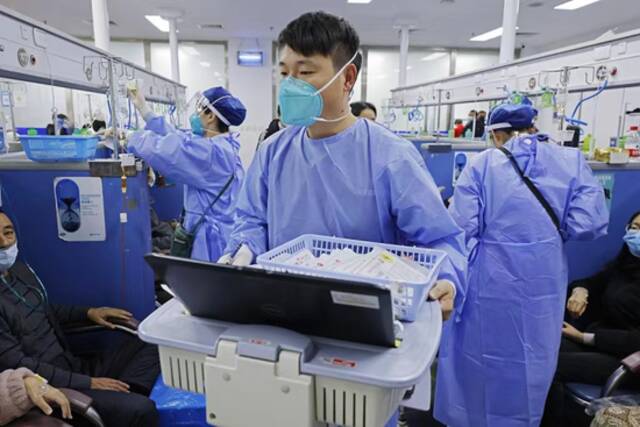 2022年12月31日晚，上海市第一人民医院松江院区内，医护人员在输液室内为患者提供医疗服务。中新社记者殷立勤摄