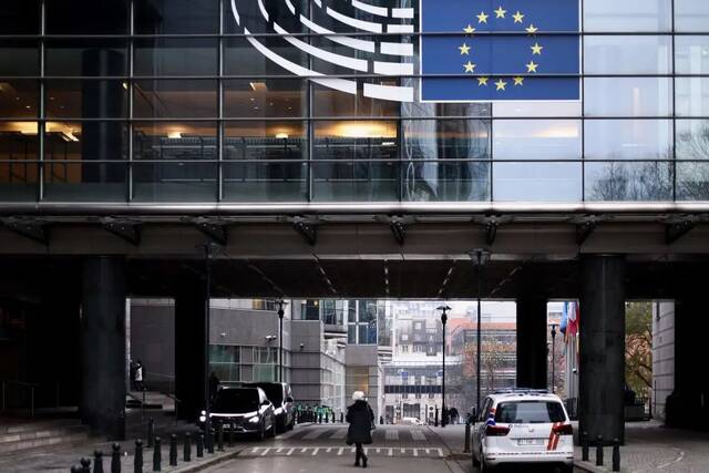 ▲当地时间2022年12月9日，比利时布鲁塞尔，一名女子走在欧洲议会门口。图/视觉中国