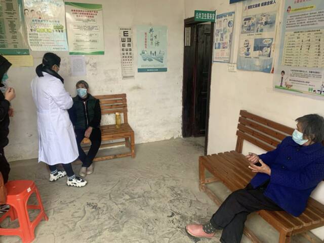 广西柳州市某村卫生室在给老人问诊和派发药品供图/郑宏彬