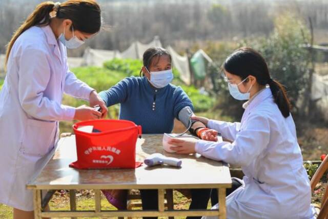 1月7日，医护人员在湖南省湘潭市雨湖区姜畲镇联映村为老人检测血氧饱和度、血压等情况。（新华社发）