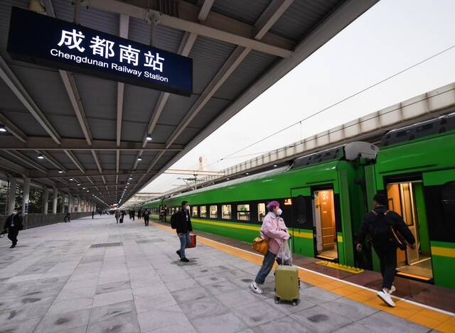 2022年12月26日，在成都南站，乘客登上新成昆铁路首发列车。新华社记者王曦摄