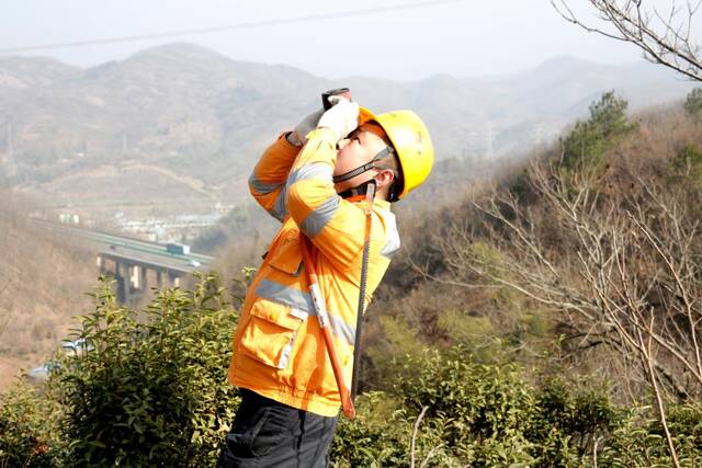 姜世洋在山顶察看线路情况。新华社记者胡锐摄