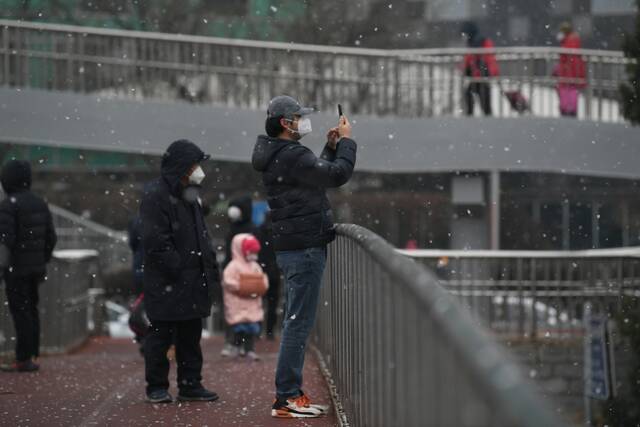 北京初雪来临，市民正在拍照。新京报记者王颖摄