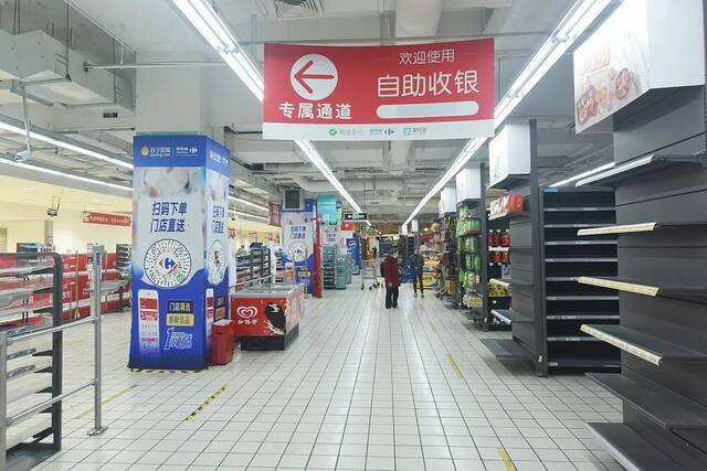  2021年11月14日，顾客在家乐福杭州涌金店里选购已经剩下不多的商品。图/视觉中国