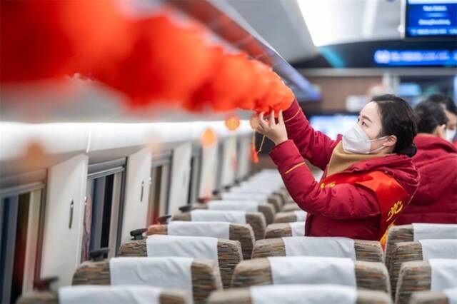  1月7日，在武汉站，乘务员在列车上挂新年灯笼。新华社记者伍志尊摄