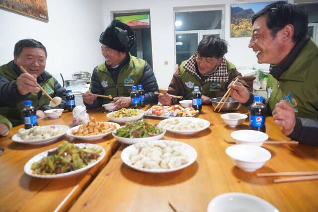1月14日晚，管护员们在一起吃饺子。新华社记者周盛盛摄