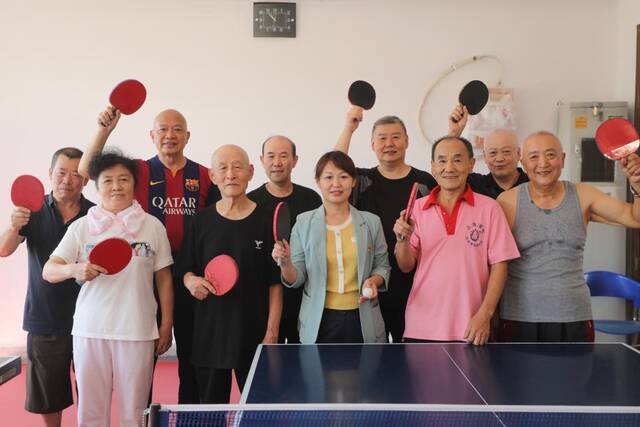 2022年7月21日，抚顺社区党委书记郝丽影（前排左三）与辖区内老人在乒乓球比赛后合影。（受访者供图）