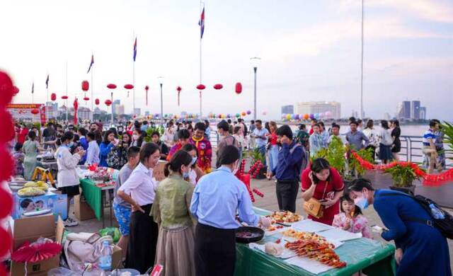 柬埔寨金边新春游园会活动现场，当地民众品尝中国传统小吃冰糖葫芦。柬埔寨皇家科学院孔子学院供图
