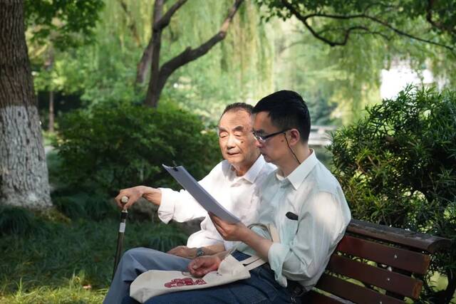 父亲陪着金晓宇在公园阅读（资料图）