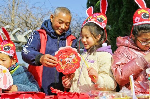 学生在手艺人的指导下，学剪纸、做灯笼、制兔帽，深入了解中国传统文化。周强摄