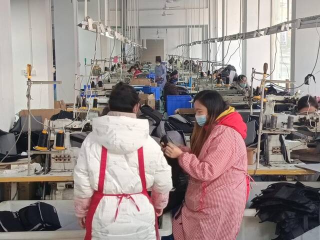 2023年1月9日，贵州省丹寨县金扬社区箱包生产扶贫车间内，职工们正在生产加工箱包。新华社记者崔晓强摄
