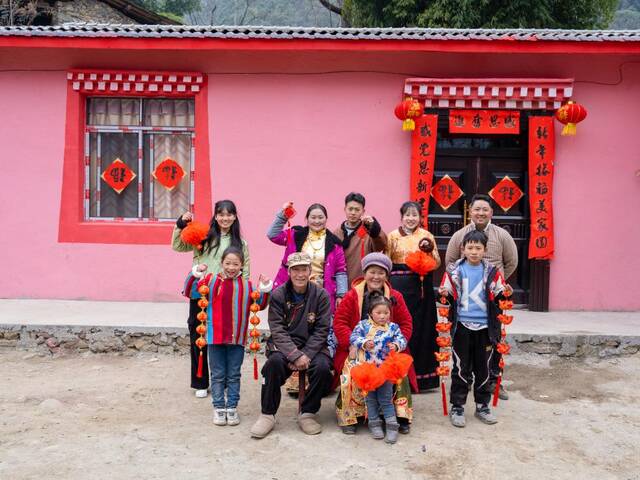 1月22日，王小军全家在新居前拍摄全家福。（石棉县融媒体中心供图）