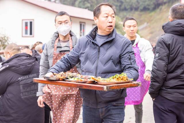 春节前夕，刚搬进新家的四川省雅安市芦山县太平镇大河村村民忙着将“九大碗”菜品端上桌。（芦山县委宣传部供图）