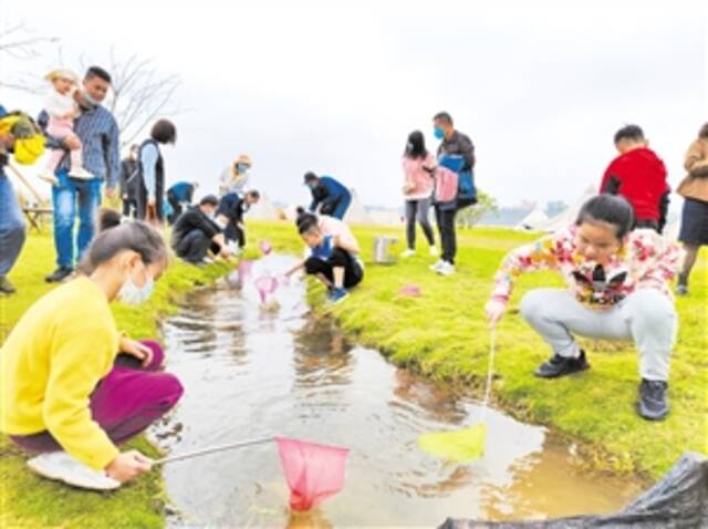 ▲北姆堆公园“捞金鱼”活动颇受孩子欢迎。本报记者王子豪摄