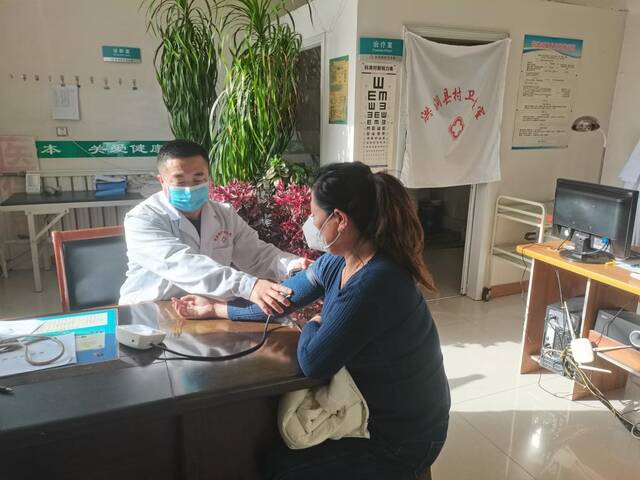 山西洪洞县郭家节村村医姬书雄正在为村民做检查。（受访者供图）