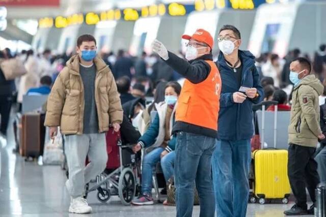 杭州东站铁路志愿者为旅客指引检票口方向。曹志刚摄
