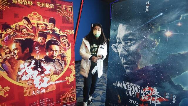 2023年1月27日，杭州，观众从一家影院的《满江红》、《流浪地球2》电影海报中间走过。视觉中国图