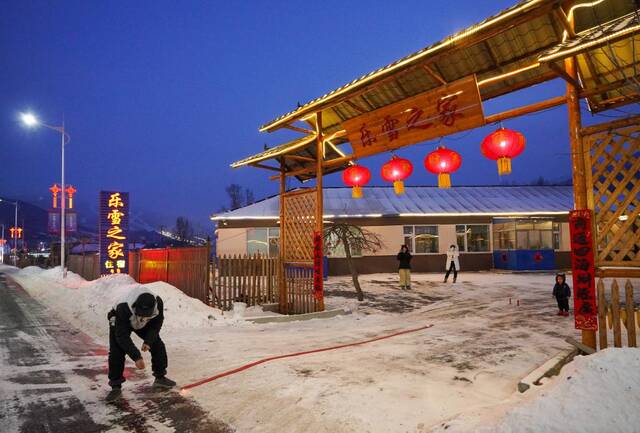 1月21日，南沟村村民邵锋在自家经营的乐雪之家民宿门口与雪友一起放鞭炮。新华社记者颜麟蕴摄