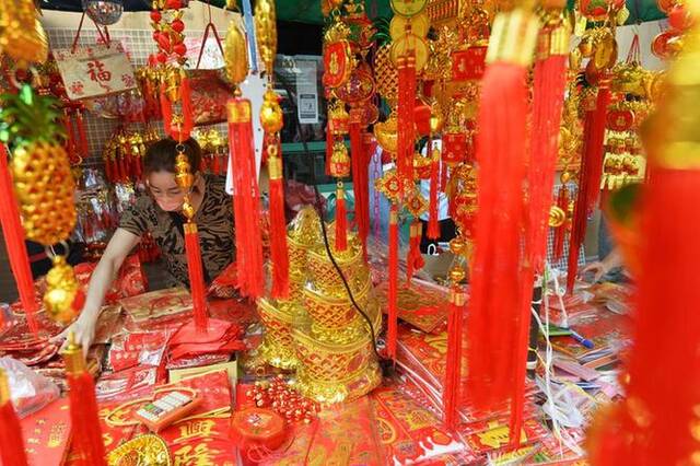 1月16日，一名商贩在泰国曼谷唐人街的摊位上摆放春节饰品。新华社发（拉亨摄）