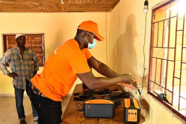 2022年1月12日，在喀麦隆恩果阿邦村，四达时代技术人员洛朗·巴拉检修电视机电源。新华社发（科普索摄）