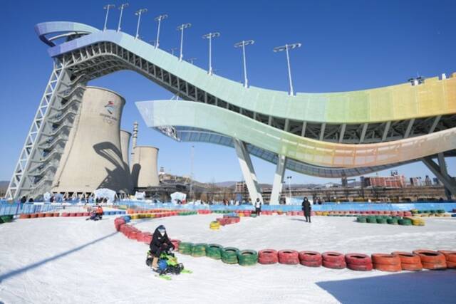 2023年1月15日，游客在首钢滑雪大跳台下体验雪地越野。2023年元旦开启的“首钢园冰雪汇”，让北京首钢滑雪大跳台成为大众冰雪乐园。新华社记者鞠焕宗摄