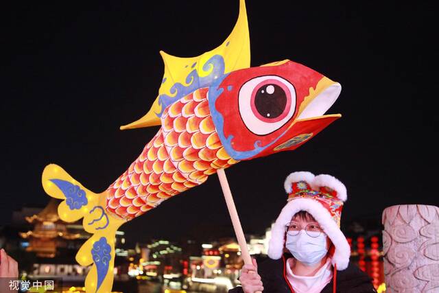 2023年2月3日，南京市，游客带着鱼灯在夫子庙景区游玩。