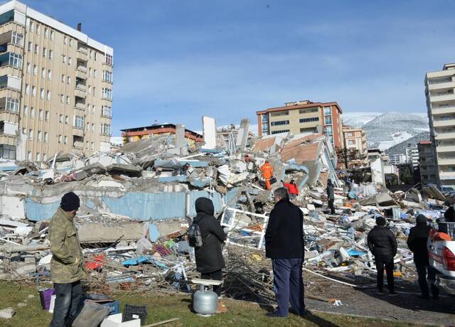 2月7日，人们聚集在土耳其南部卡赫拉曼马拉什市一处地震废墟。新华社发（穆斯塔法·卡亚摄）