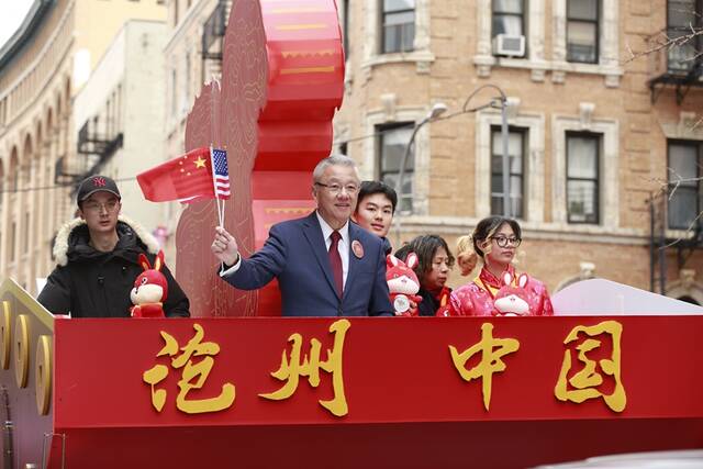 美中公共事务协会执行会长滕绍骏在沧州花车上向观众挥手示意。赵晓乐摄