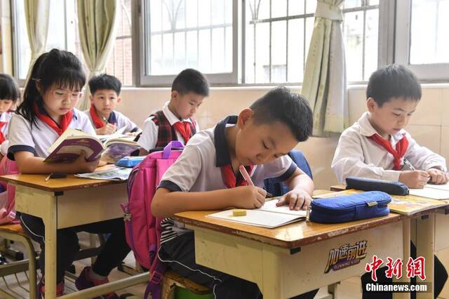 资料图：广州市朝天小学部分低年级学生放学后在特定的托管教室内做作业。中新社记者陈骥旻摄