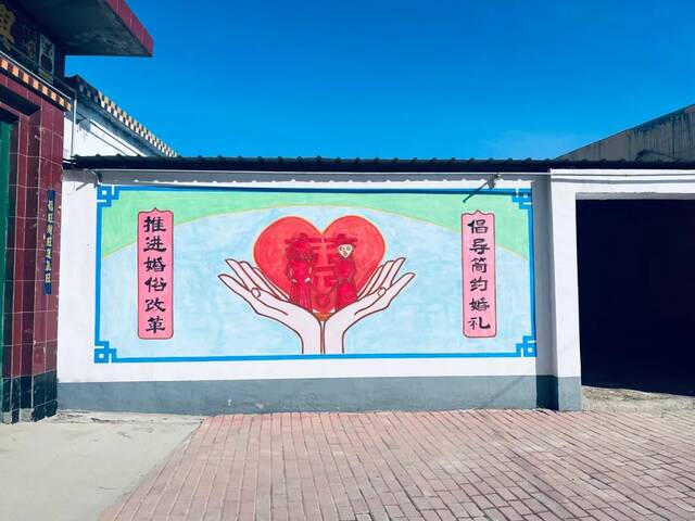 ▲2月1日，大庄村村口墙上的“零彩礼”宣传画。新京报记者陈亚杰摄