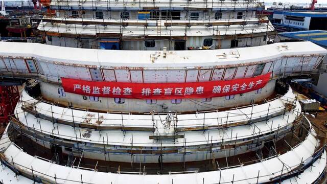 2022年8月3日，在中国船舶集团旗下上海外高桥造船有限公司，工作人员在中国首制大型邮轮外部进行施工。摄影/本刊记者殷立勤