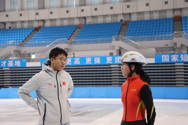 2月7日，在七台河体育中心，教练李国锋（左）给刘厶函（右）讲解短道速滑技巧。新华社记者戴锦镕摄