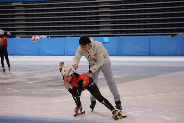 2月7日，在七台河体育中心，刘厶函（左）在教练李国锋（右）的指导下练习短道速滑。新华社记者戴锦镕摄