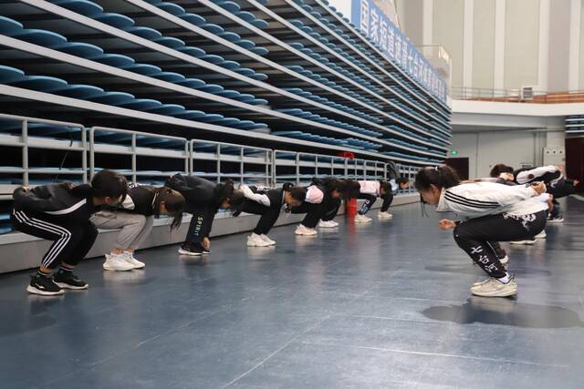 2月7日，在七台河体育中心，刘厶函正在和队友们热身。新华社记者戴锦镕摄