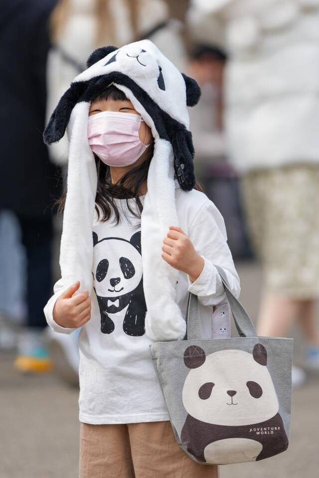 2月19日，在日本东京上野动物园，一名小朋友穿戴着大熊猫服饰游览。新华社记者张笑宇摄