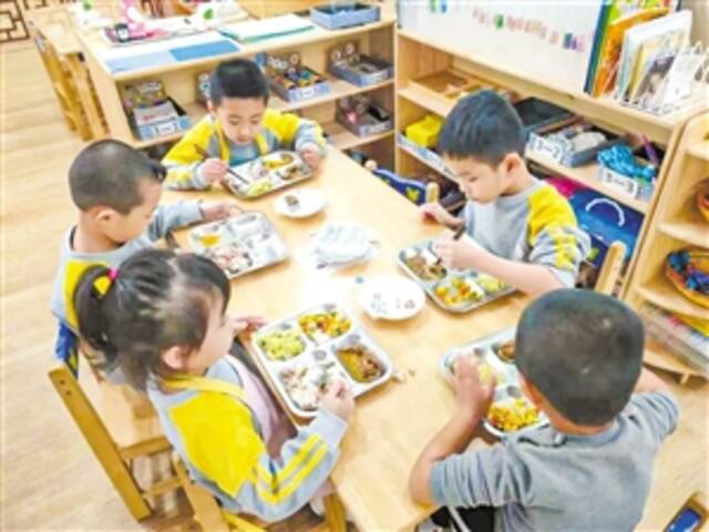2月20日，在海口市港湾幼儿园，学生们在享用午餐。本报记者孙士杰摄