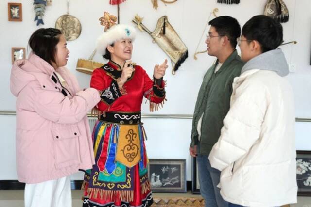  2月23日，在黑龙江省同江市八岔赫哲族乡八岔村伊玛堪传习所，刘蕾（左二）与年轻人交流。新华社记者王建威摄