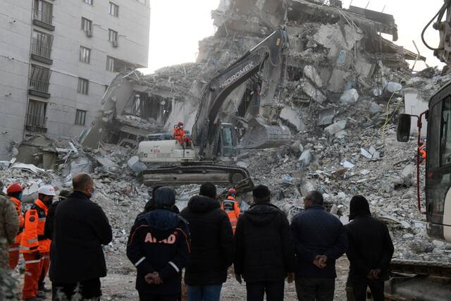2月21日，工作人员利用大型机械在土耳其哈塔伊省清理废墟。新华社发（穆斯塔法·卡亚摄）