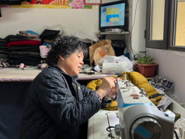 裁缝刘师傅在缝纫机前改衣服。新华社记者马晓洁摄