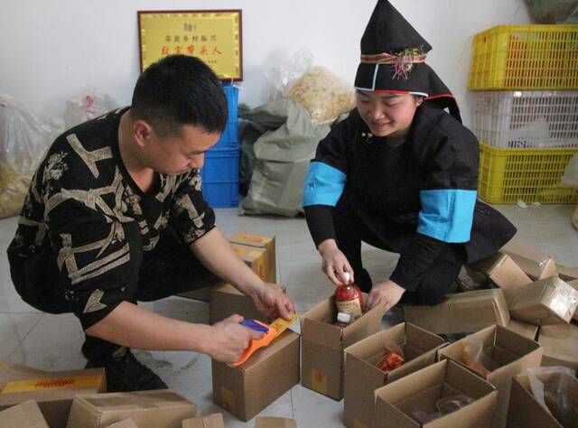 3月4日，榕江县的“直播达人”王启红（右）在贵州榕江两汪乡两汪村打包产品。（陶明霞摄）