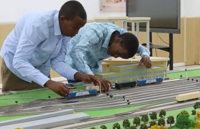 2022年9月19日，在位于吉布提首都吉布提市的吉布提工商学校，学生在鲁班工坊铁道运营沙盘教学区学习。（新华社）