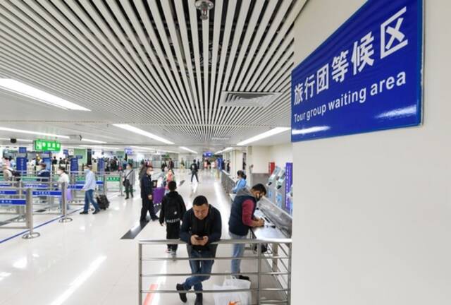  3月15日，旅客在深圳罗湖口岸入境检查大厅准备入境。新华社记者毛思倩摄
