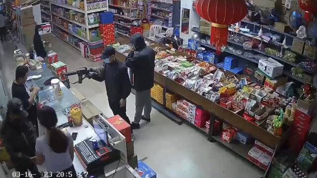 3月16日晚，女店员（左下穿淡紫色上衣长发女子）被绑匪持枪带走。视频截图
