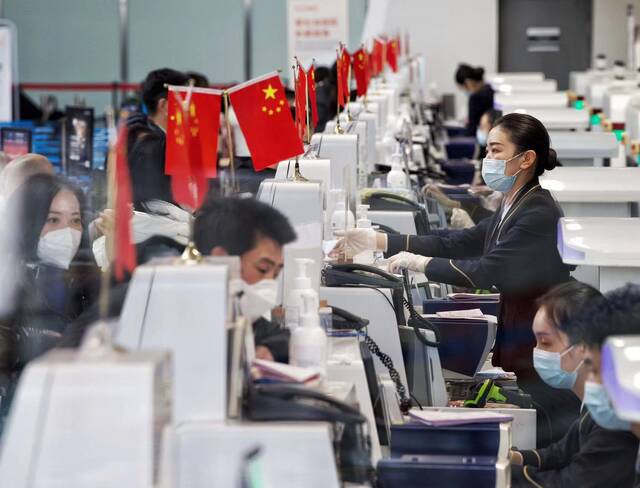 大兴机场工作人员正在为旅客办理值机手续。新京报记者陶冉摄