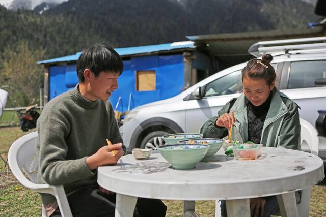 3月24日，白玛德吉和丈夫殷合在民宿门前吃饭。新华社记者格桑朗杰摄